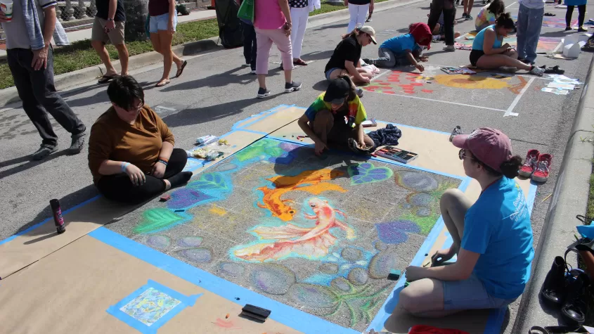 The first place winners of our high school street painting competition, &quot;Chalk Block&quot;,  in the process of working on their winning piece as a team.